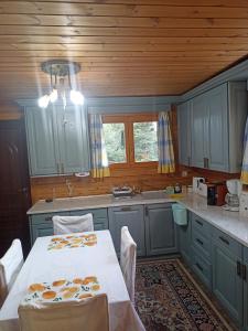 una cocina con armarios azules y una mesa blanca con sillas en Rados chalet, en Rádhos