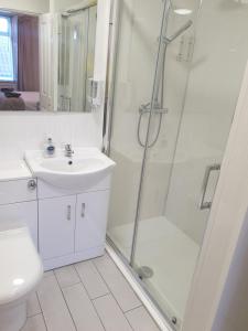 ein Bad mit einer Dusche, einem Waschbecken und einem WC in der Unterkunft The Coastal Inn in Cellardyke