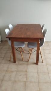 una mesa de madera con 4 sillas blancas alrededor en Patio Olmos Flores en Córdoba