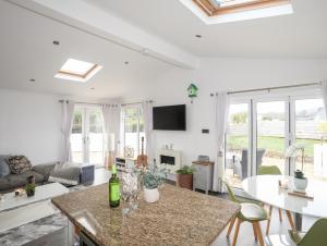 a kitchen and living room with a table and chairs at The Warren U5 in Abersoch