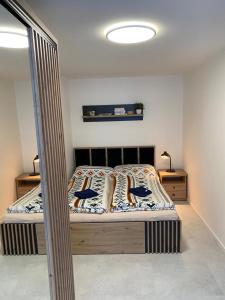 een slaapkamer met een bed met twee blauwe vogels erop bij Apartmán Emilka in Janov nad Nisou