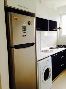 eine Küche mit einem Kühlschrank und einer Waschmaschine in der Unterkunft Cozy Studio - Floreasca/​Dorobanti - Bucharest in Bukarest