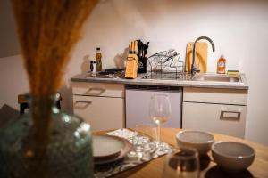 a kitchen with a table with a wine glass at Le Nid • Cocoon • Netflix • Proche Centre-Ville in Châteauroux