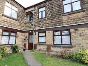 a brick house with windows and a yard at Amber Cottage in Matlock