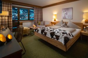 a bedroom with a bed with a cow blanket at Hotel-Pension Schattberg in Saalbach Hinterglemm