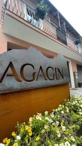 un panneau de carlin devant un bâtiment fleuri dans l'établissement Agriturismo Agagin, à Agaggio Inferiore