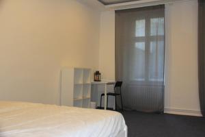 una camera con letto, scrivania e finestra di 3 Zimmer Apartment am Leopoldplatz a Berlino