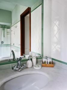 a bathroom sink with a large mirror above it at Serendipity Apartments - Brera in Milan