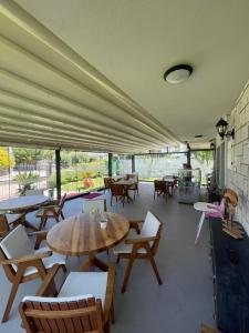 a large room with tables and chairs and windows at Dalyan Risus Suite in Çeşme