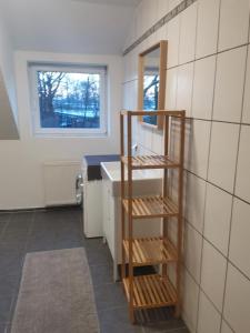 a bathroom with a wooden shelf next to a sink at Monteurwohnung in Wesermarsch, Küche, Einzelbetten, Stedinger Landhotel in Berne