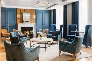 a lobby with blue chairs and a fireplace at The Wallace Hotel in New York