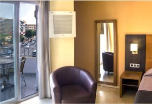 a living room with a chair and a balcony at Rincón Sol in Rincón de la Victoria