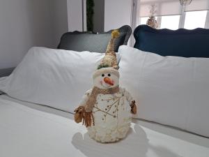 a toy snowman sitting on top of a bed at La Casita del Arco Panorámico in San Pedro