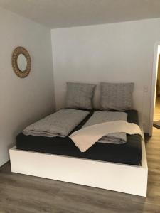 Bett in einem Zimmer mit einer weißen Wand in der Unterkunft Sonthof City in Sonthofen