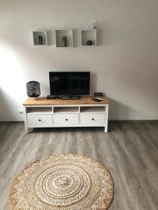 ein Wohnzimmer mit einem TV und einem Tisch mit einem Teppich in der Unterkunft Sonthof City in Sonthofen