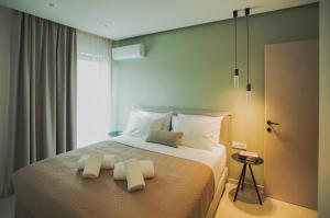 una camera da letto con un letto e due asciugamani di Celine Luxury Apartments & Suites ad Ágios Nikólaos
