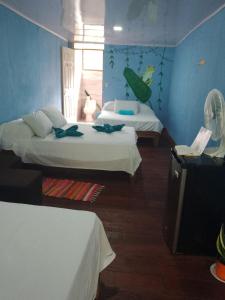 pokój z dwoma łóżkami i telewizorem w obiekcie Hotel Green Mountain Cahuita w mieście Cahuita