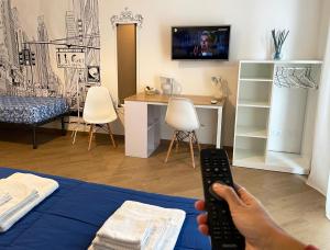 una persona con mando a distancia en un dormitorio en Lucky Inn, La Locanda della Fortuna, en Palermo