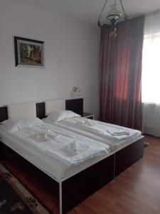 a large bed in a room with a window at Hotel Turist in Pucioasa