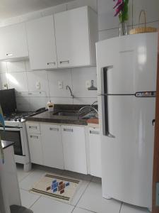 eine Küche mit weißen Schränken und einem weißen Kühlschrank in der Unterkunft Ap Completo na zona Nobre com 3 quartos, sendo 1 suíte in Teresina