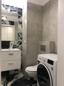 ein Badezimmer mit einem WC und einer Waschmaschine in der Unterkunft Apartment by Gustav in Breslau