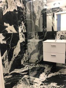 ein schwarzweißes Bad mit einem Waschbecken und einem Spiegel in der Unterkunft Apartment by Gustav in Breslau