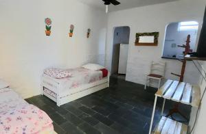 1 dormitorio con 2 camas y una cruz en la pared en PousadaRecanto684Guarujá, en Guarujá