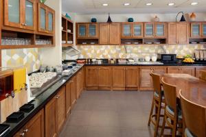 a large kitchen with wooden cabinets and a bar at Hyatt Place Princeton in Princeton