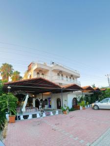 a building with a car parked in a parking lot at Murat Hotel in Demre