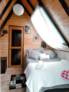 1 dormitorio con 2 camas en una cabaña de madera en Glamping refugio Gaia, en Paipa