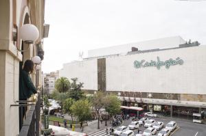 Blick auf eine Stadtstraße mit vor einem Gebäude geparkt in der Unterkunft Hotel Duquesa in Sevilla