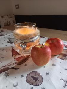 dos manzanas sentadas en una mesa con una vela en Pferdehof Ansteingut, en Sluderno