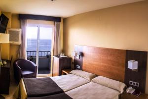 a hotel room with a bed and a window at Rincón Sol in Rincón de la Victoria