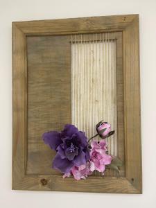 a picture of a purple flower in a wooden frame at Dalyan Risus Suite in Çeşme