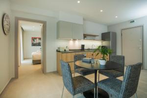 cocina y comedor con mesa y sillas en Celine Luxury Apartments & Suites, en Agios Nikolaos