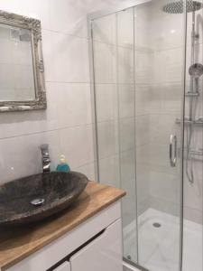 y baño con lavabo y ducha acristalada. en Apartament Centrum, en Suwałki