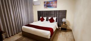 a bedroom with a large bed with red pillows at Golden Hotel in Amman