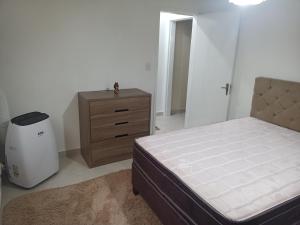 a bedroom with a bed and a dresser in it at Apto em Santa Maria in Santa Maria