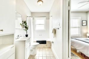 a white bathroom with a toilet and a sink at Global Cup The Vintage Stellar on Lower-Greenville in Dallas