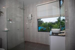 a bathroom with a shower and a sink and a window at Siem Reap Homesteading in Siem Reap