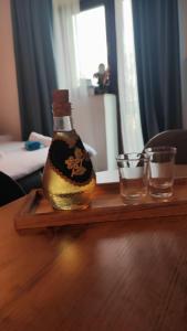 butelka alkoholu na stole z dwoma kieliszkami w obiekcie Studio apartman Bruna w mieście Ðakovo