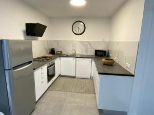 una cocina con electrodomésticos blancos y un reloj en la pared en S&C HOSTING, en Celorico de Basto