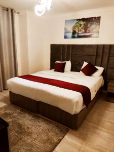 a bedroom with a large bed with red pillows at Golden Hotel in Amman