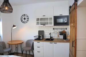 a kitchen with white cabinets and a table with chairs at Hafenkoje Zum Anker in Wolgast