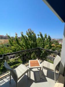 a patio with chairs and a table on a balcony at Dalyan Risus Suite in Çeşme