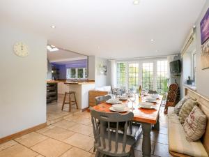 a dining room and living room with a table and chairs at 1 Northside Cottages in Godalming