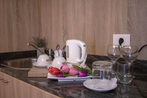 eine Küchentheke mit einem Mixer, Blumen und Gläsern in der Unterkunft HOtello guest suites in Jounieh