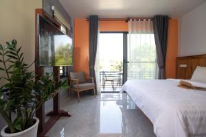 a bedroom with a large bed and a large window at Siem Reap Homesteading in Siem Reap