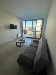 uma sala de estar com um sofá e uma mesa em Edificio Vista a 50 metros del mar a estrenar em Mar del Plata