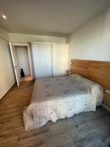 a bedroom with a large bed with a wooden headboard at Edificio Vista a 50 metros del mar a estrenar in Mar del Plata
